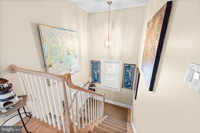 staircase with a notable chandelier