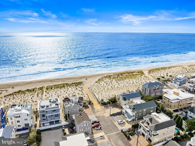 birds eye view of property with a water view and a beach view