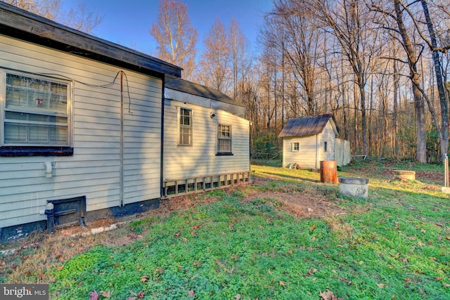 view of side of home with a shed and a lawn