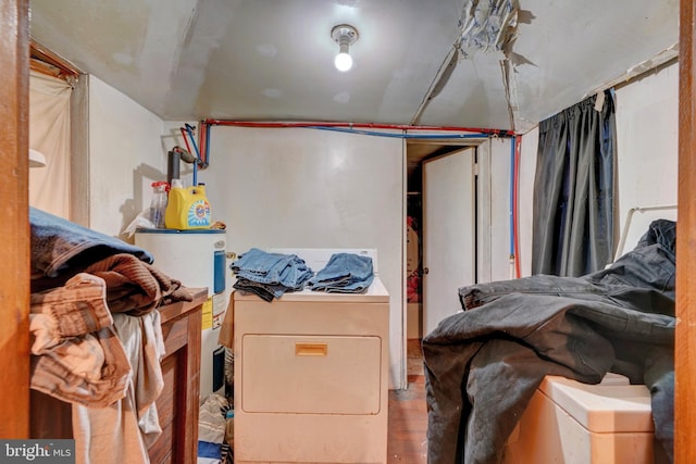 laundry area with hardwood / wood-style flooring, washer / dryer, and electric water heater