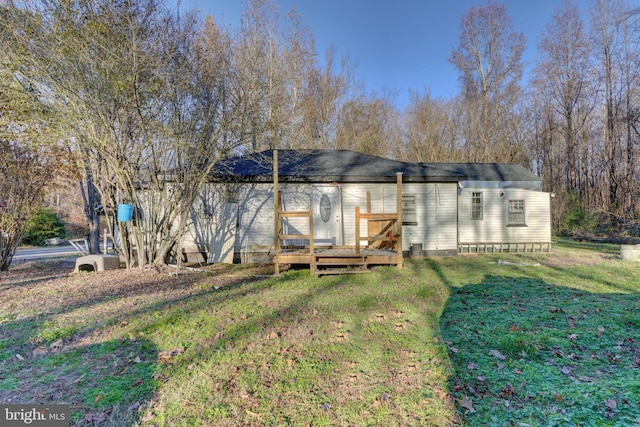 rear view of house featuring a deck and a yard