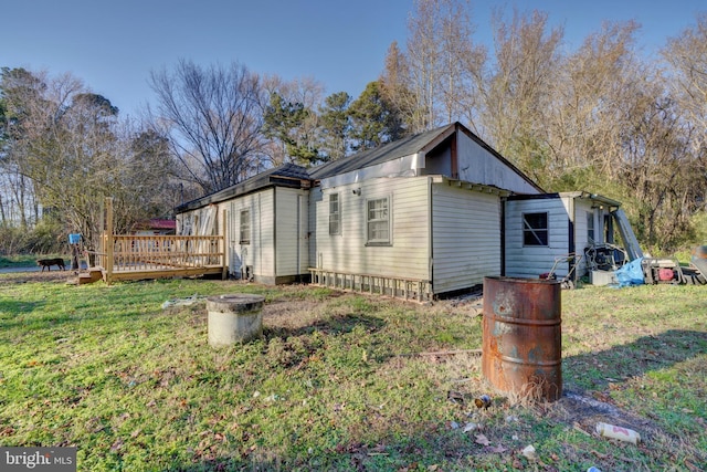 view of side of home with a lawn and a wooden deck