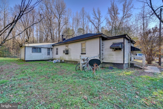 back of property featuring a lawn and cooling unit