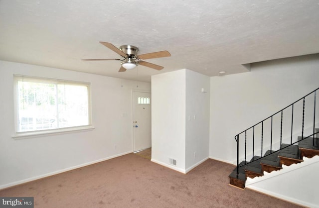 interior space featuring carpet, a textured ceiling, and ceiling fan