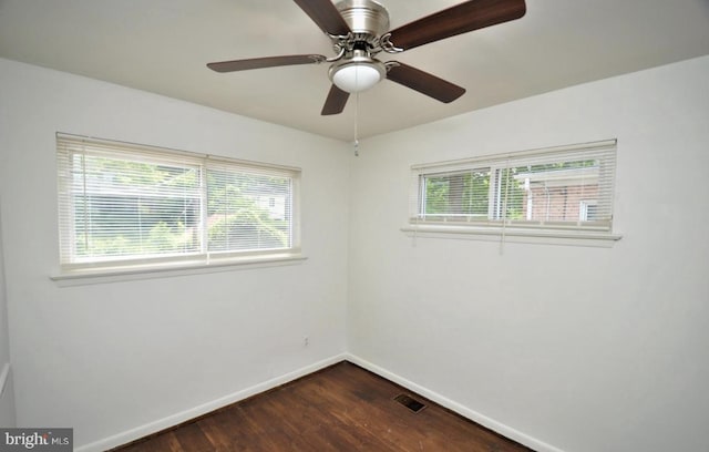 unfurnished room with dark hardwood / wood-style floors, a healthy amount of sunlight, and ceiling fan