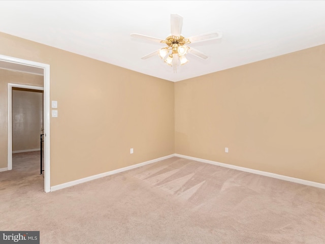 empty room featuring ceiling fan and light colored carpet