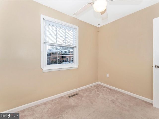 carpeted spare room featuring ceiling fan