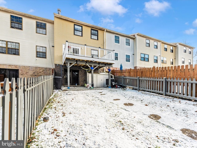 snow covered rear of property featuring a storage unit and cooling unit