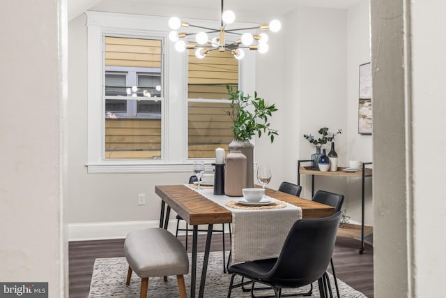 dining space featuring hardwood / wood-style flooring and an inviting chandelier