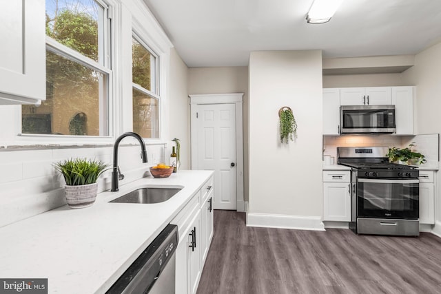 kitchen featuring decorative backsplash, appliances with stainless steel finishes, dark hardwood / wood-style flooring, sink, and white cabinetry