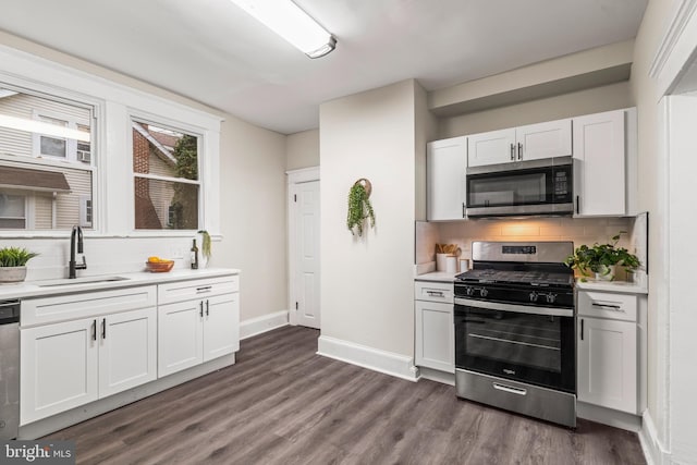 kitchen with appliances with stainless steel finishes, backsplash, dark wood-type flooring, sink, and white cabinets