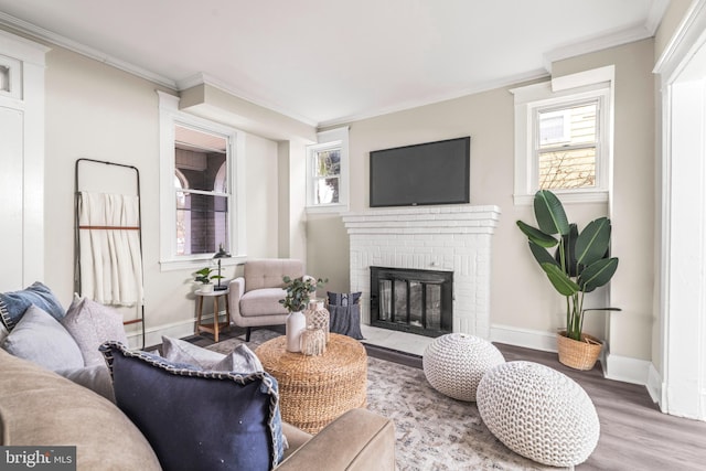 living room featuring hardwood / wood-style floors, a brick fireplace, and crown molding