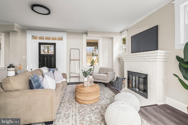 living room featuring a brick fireplace, crown molding, and light wood-type flooring