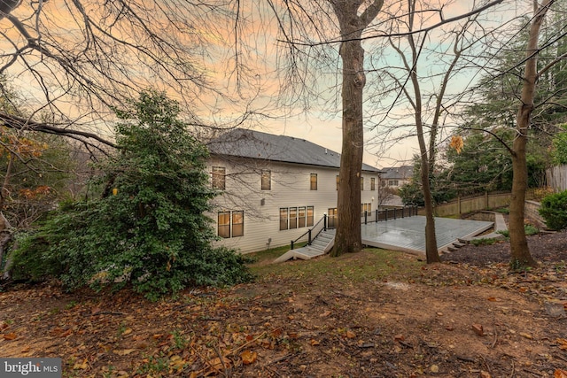 property exterior at dusk featuring a deck