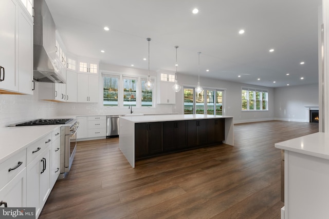 kitchen featuring stainless steel appliances, white cabinetry, and a spacious island