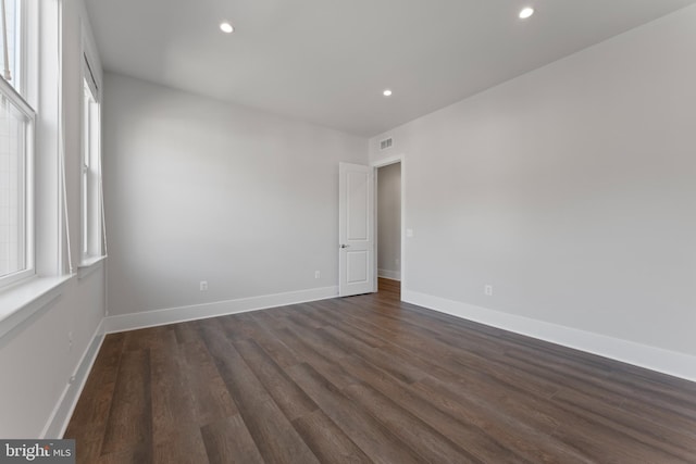 empty room with plenty of natural light and dark hardwood / wood-style floors