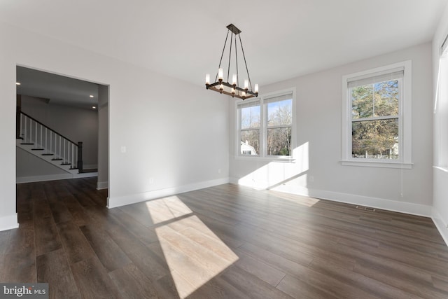 unfurnished dining area featuring dark hardwood / wood-style floors and an inviting chandelier