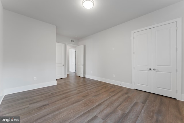 unfurnished bedroom featuring a closet and hardwood / wood-style floors