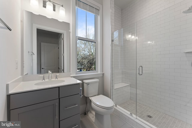 bathroom featuring vanity, toilet, and an enclosed shower