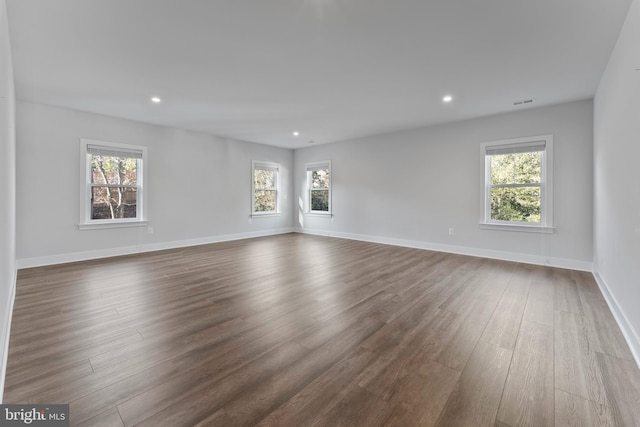 unfurnished room featuring dark hardwood / wood-style floors and a healthy amount of sunlight