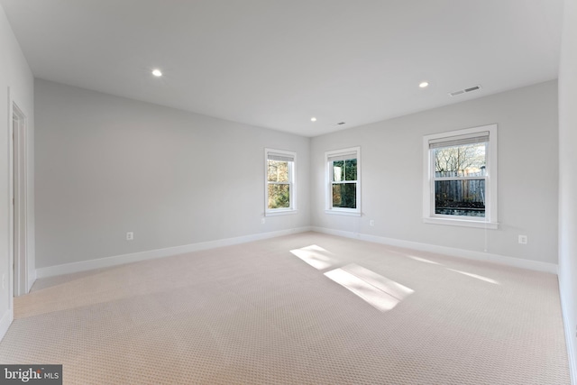 spare room featuring light colored carpet