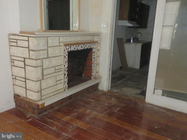 unfurnished living room with hardwood / wood-style floors and sink