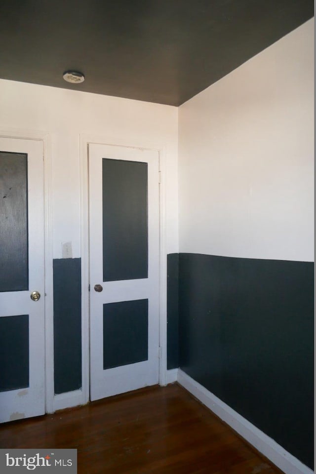 unfurnished room with dark wood-type flooring