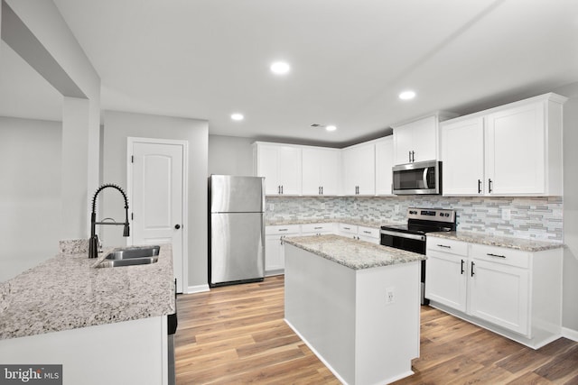 kitchen with white cabinetry, light hardwood / wood-style flooring, sink, and appliances with stainless steel finishes