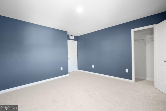 unfurnished bedroom with light colored carpet and a closet