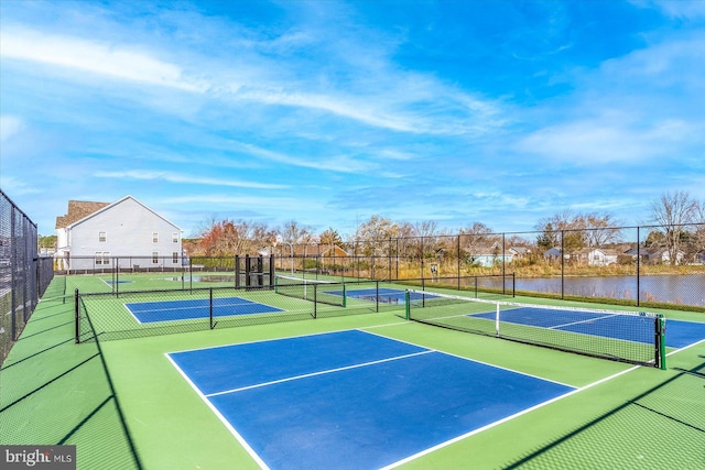 view of tennis court with basketball court and a water view