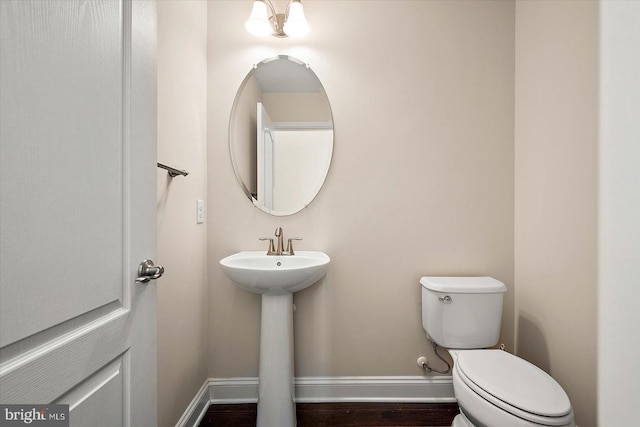 bathroom with toilet, wood-type flooring, and sink