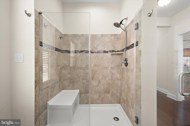 bathroom with a shower with shower door and hardwood / wood-style flooring