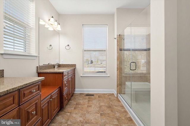 bathroom with vanity, plenty of natural light, and a shower with shower door