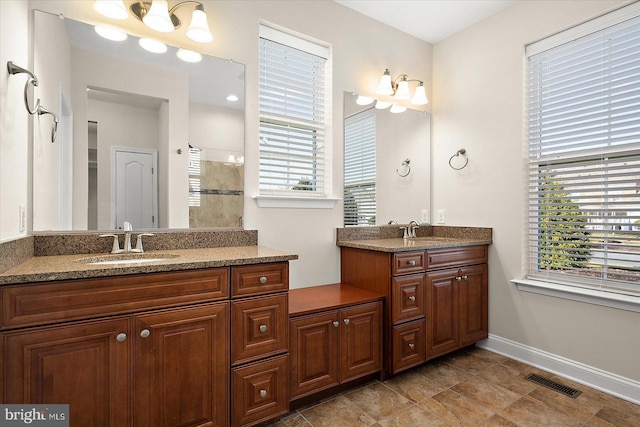 bathroom featuring a tile shower, a wealth of natural light, and vanity