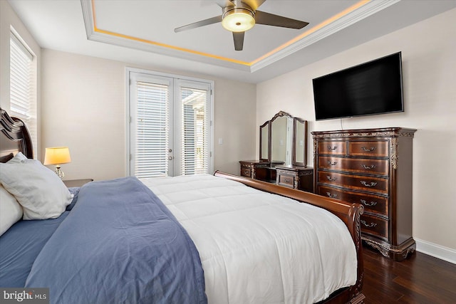 bedroom featuring multiple windows, a raised ceiling, and ceiling fan