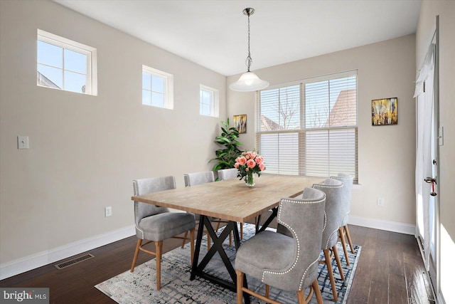 dining space featuring a wealth of natural light and dark hardwood / wood-style flooring