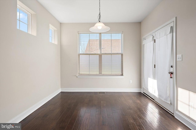 unfurnished dining area with dark wood-type flooring