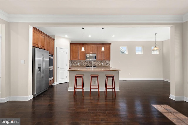 kitchen with a kitchen island with sink, hanging light fixtures, stainless steel appliances, dark hardwood / wood-style flooring, and decorative backsplash