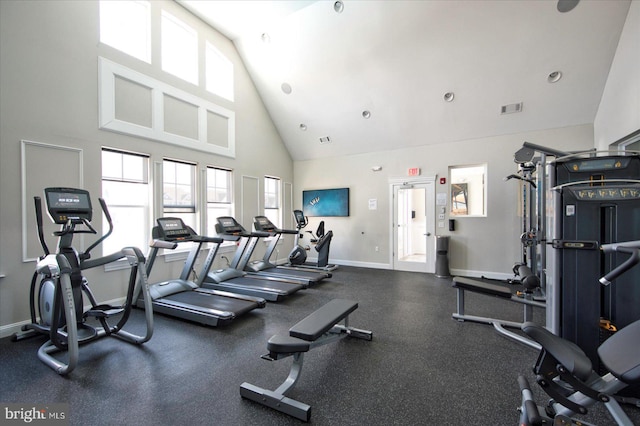 exercise room with high vaulted ceiling