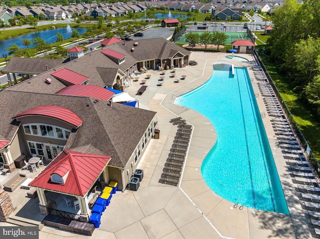 view of swimming pool featuring a water view and a patio