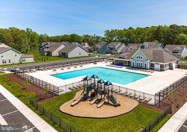 view of swimming pool featuring a playground and a lawn