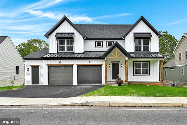 modern inspired farmhouse with a front lawn and a garage