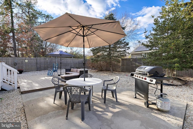 view of patio featuring a wooden deck and a grill