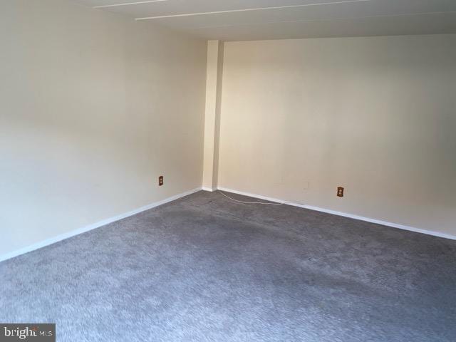 spare room featuring dark carpet