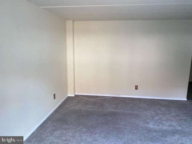 spare room with dark carpet