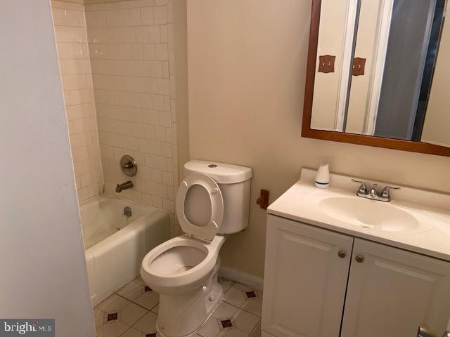 full bathroom featuring tile patterned floors, vanity, toilet, and tiled shower / bath