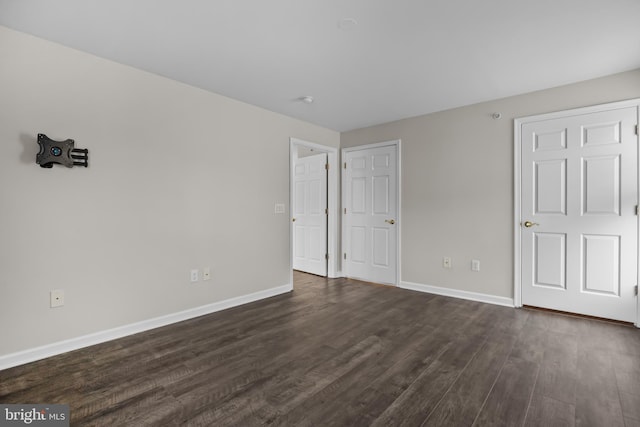 unfurnished bedroom with dark hardwood / wood-style floors