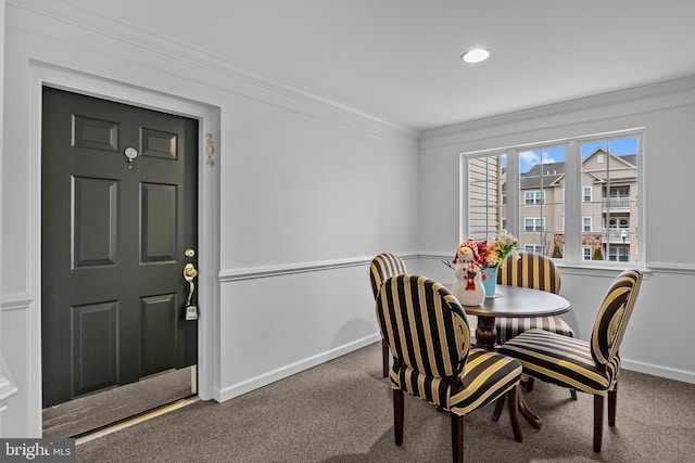 carpeted dining room featuring ornamental molding