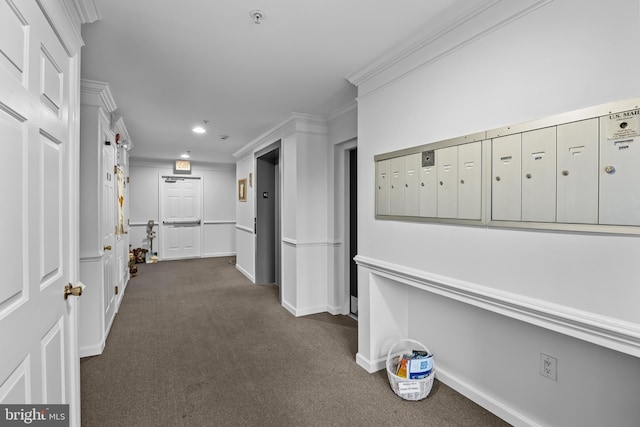 hall featuring crown molding, a mail area, and dark colored carpet