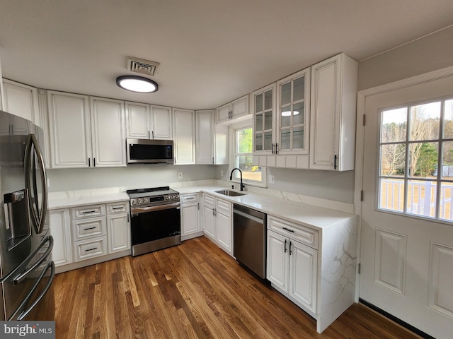 kitchen featuring white cabinets, appliances with stainless steel finishes, a wealth of natural light, and sink